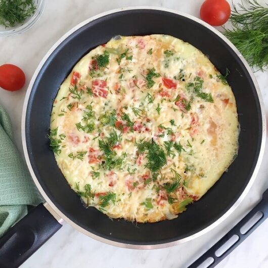 Омлет с спелыми томатами, овощами и сырной корочкой